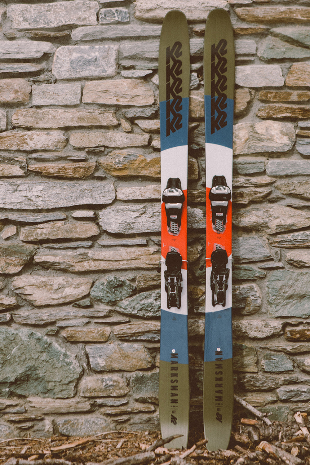 A pair of skis leaning against a stone wall